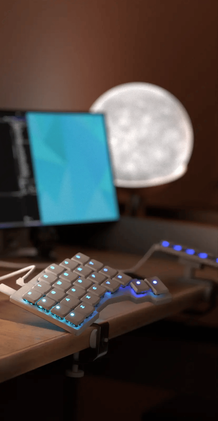 Two C-Clamps on a desk, either side of the desktop, with a white Voyager on each